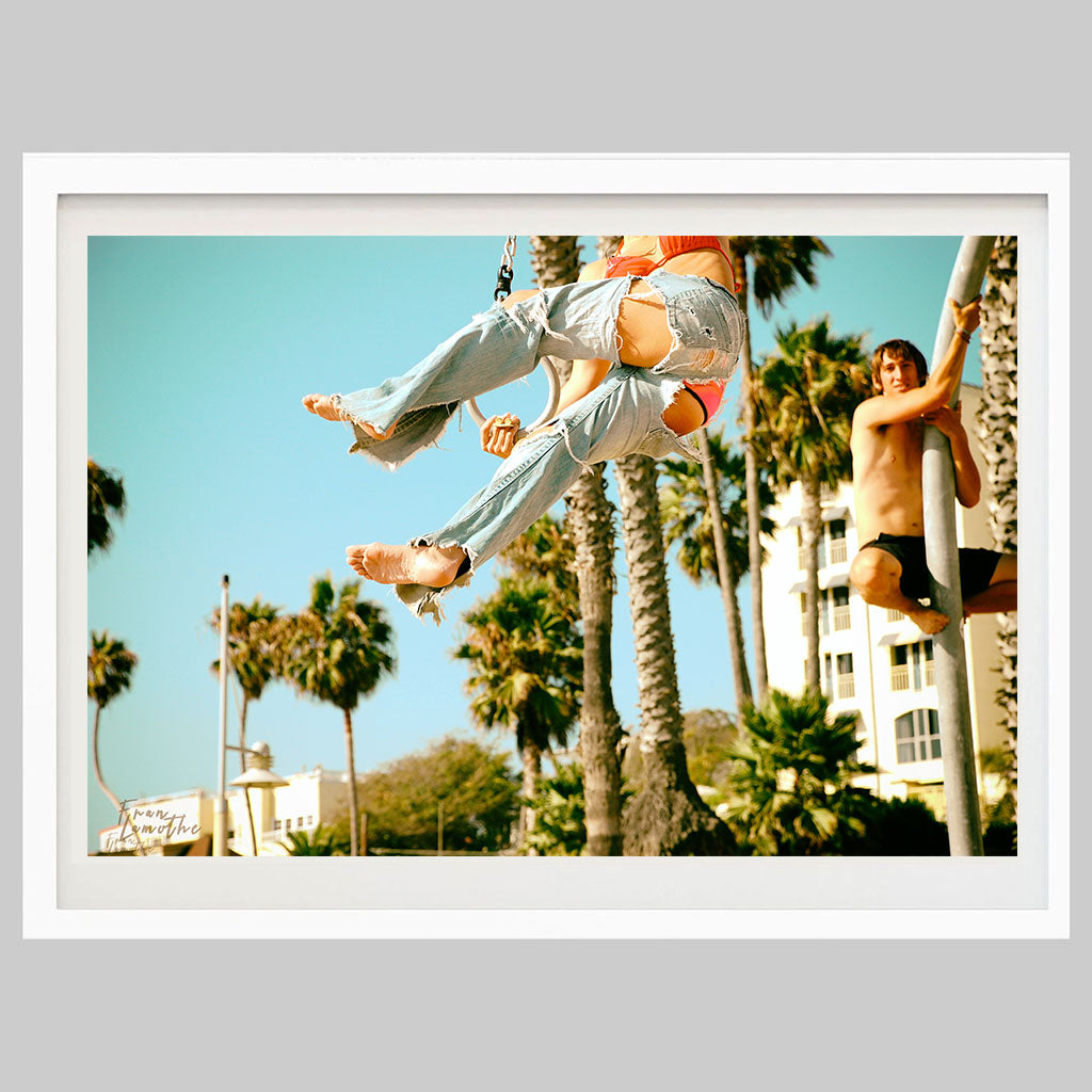 Girl with ripped jeans and man watching from a pole. flying rings, Santa Monica, California.